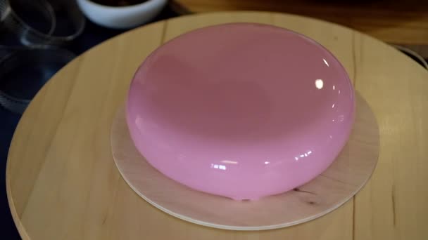 Bolo de mousse na moda com esmalte de espelho rosa na base de madeira. Sobremesa moderna. — Vídeo de Stock