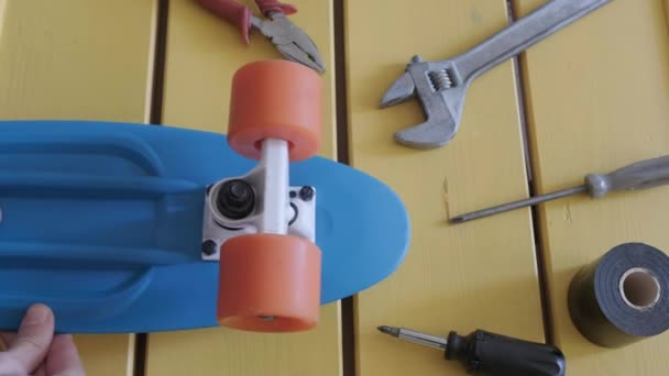 Meister im Service repariert Skateboard. Kleiner Junge wird Minicruiser reparieren. — Stockvideo