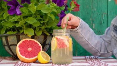 Çocuk açık havada taze limonata içiyor..