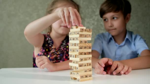 Crianças jogam um jogo de tabuleiro de madeira na mesa em casa. — Vídeo de Stock
