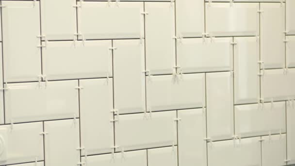 Arbeta tiler om vit keramik kakel i en sill ben mönster på väggen i köket. — Stockvideo