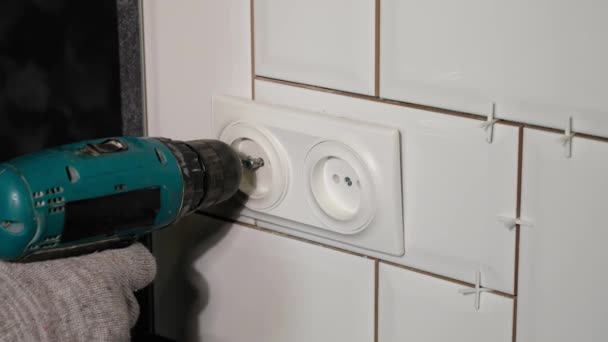 Eletricista instala uma tomada dupla na cozinha com uma chave de fenda. — Vídeo de Stock