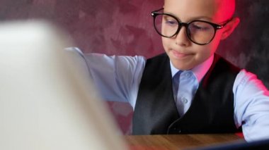 Modern çocuk internette dizüstü bilgisayarla alışveriş yapıyor. Gözlüklü genç kredi kartı kullanarak internetten sipariş veriyor..