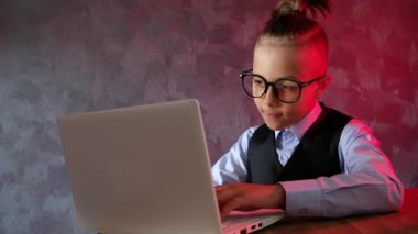 Genç iş adamı dizüstü bilgisayar kullanıyor. Gözlüklü modern çocuk. Küçük çocuk ekrana baktığında şaşırıyor..