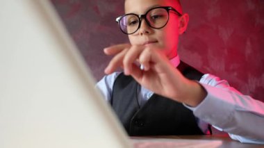 Genç iş adamı dizüstü bilgisayar kullanıyor. Gözlüklü modern çocuk. Küçük çocuk çalışmaktan yoruldu..