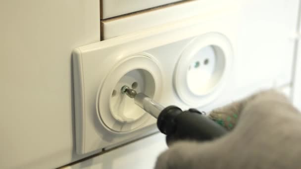 Electricista instala un enchufe doble en la cocina con un destornillador. — Vídeos de Stock