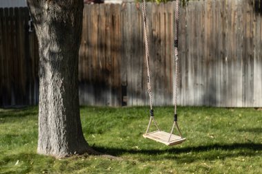 Avluda asılı rustik ahşap ağaç salıncak kapatın.