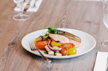 Sebzeli somon ve beyaz tabakta sos..