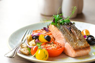 Kızarmış somon bifteği, sebze ve salata.