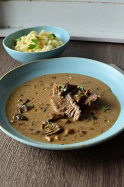 Seramik kasede mantarlı, patatesli, havuçlu, soğanlı, sarımsaklı ve maydanozlu biftek güveci.