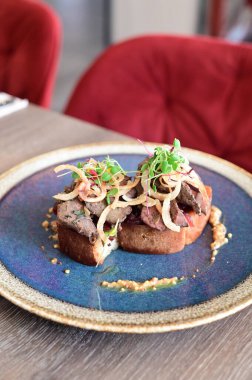 Kaz ciğeri ile kaplanmış kızarmış ekmeğin yakın çekim görüntüsü doku, renk ve gurme sunumu, mutfak ve yemek fotoğrafçılığı için mükemmel.