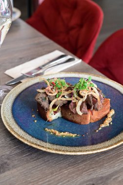Kaz ciğeri ile kaplanmış kızarmış ekmeğin yakın çekim görüntüsü doku, renk ve gurme sunumu, mutfak ve yemek fotoğrafçılığı için mükemmel.