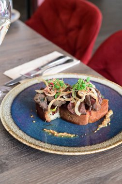 Kaz ciğeri ile kaplanmış kızarmış ekmeğin yakın çekim görüntüsü doku, renk ve gurme sunumu, mutfak ve yemek fotoğrafçılığı için mükemmel.