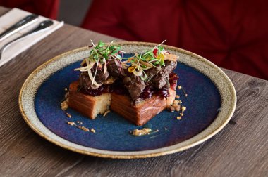 Kaz ciğeri ile kaplanmış kızarmış ekmeğin yakın çekim görüntüsü doku, renk ve gurme sunumu, mutfak ve yemek fotoğrafçılığı için mükemmel.