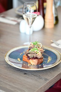 Kaz ciğeri ile kaplanmış kızarmış ekmeğin yakın çekim görüntüsü doku, renk ve gurme sunumu, mutfak ve yemek fotoğrafçılığı için mükemmel.