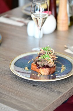 Kaz ciğeri ile kaplanmış kızarmış ekmeğin yakın çekim görüntüsü doku, renk ve gurme sunumu, mutfak ve yemek fotoğrafçılığı için mükemmel.