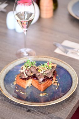 Kaz ciğeri ile kaplanmış kızarmış ekmeğin yakın çekim görüntüsü doku, renk ve gurme sunumu, mutfak ve yemek fotoğrafçılığı için mükemmel..
