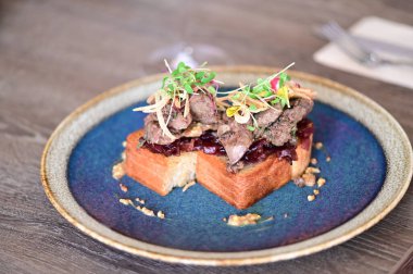 Kaz ciğeri ile kaplanmış kızarmış ekmeğin yakın çekim görüntüsü doku, renk ve gurme sunumu, mutfak ve yemek fotoğrafçılığı için mükemmel..