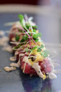 Kızarmış ekmek ve kırsal bir tabakta mikro yeşilliklerle servis edilen, bir restoran ortamında ahşap bir masada sunulan, Avrupa mutfağını ön plana çıkaran,.