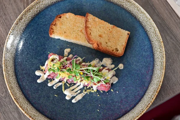 Salata ve peynirli lezzetli etli carpaccio. Tabakta servis edilir.