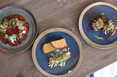 Yakın plan doğranmış dana tartı kremalı mayonez, taze otlar ve narin garnitürle servis edilir. Restoran tarzında zarif bir şekilde kaplanmış, etin detaylı dokusunu vurguluyor..