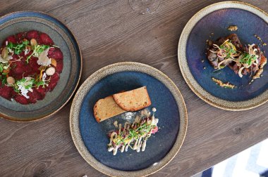 Yakın plan doğranmış dana tartı kremalı mayonez, taze otlar ve narin garnitürle servis edilir. Restoran tarzında zarif bir şekilde kaplanmış, etin detaylı dokusunu vurguluyor..