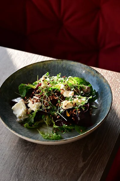 Kızarmış pancar kökü ve kremalı peynirli, yeşillik ve otlarla süslenmiş taze salatanın yakın görüntüsü. Renk ve lezzet dolu canlı ve sağlıklı bir yemek, modern mutfak, sağlıklı beslenme ve yemek fotoğrafçılığı için mükemmel..