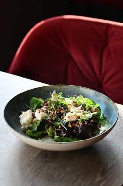 Masada bir tabak taze yeşil salata.