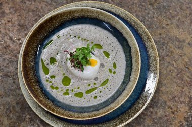 Geleneksel Çek mantar çorbası haşlanmış yumurta ve bir tutam yağla servis edilir. Çek mutfağının otantik tadını yakalayan, sonbahar ve geleneksel yemek fotoğrafçılığı için mükemmel bir ev yapımı kırsal ve rahatlatıcı yemek..