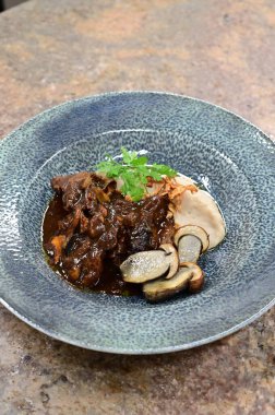 Bir tabak sığır eti ve mantar sosunun yüksek açılı çekimi.