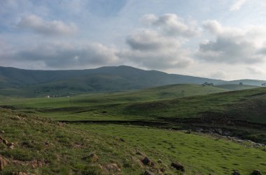 Günbatımı bulutlar, tepeler ve çayır ile bahar manzarada. Zlatibor dağın alan, Sırbistan