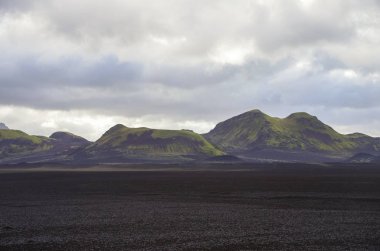Landmannalaugar, İzlanda volkanik Vadisi yosun kaplı önce tarafından siyah kül kaplı lav alanı