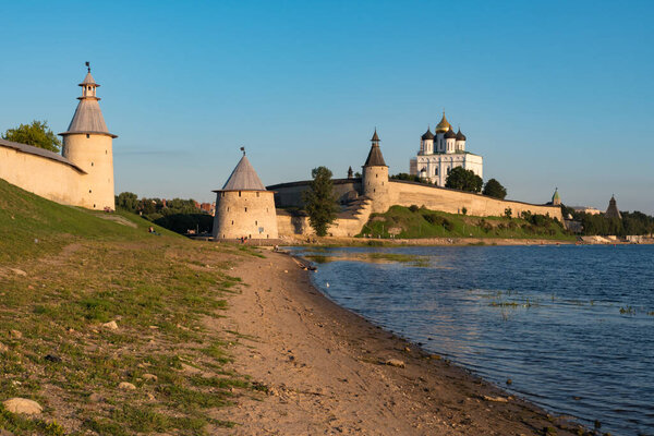 Pskov Kremlin view from river Pskova creek. Towers, wall and Trinity cathedral on background.