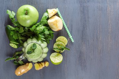 Taze yeşil smoothies maydanoz, zencefilli, elma, limon, salatalık ve siyah ahşap bir masa üzerinde bir bardak nane. Üstten görünüm. Sağlıklı gıda. Kopya alanı