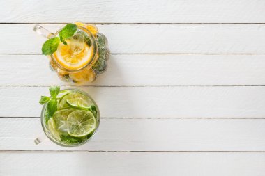 İki cam bardak kireç ve limon Beyaz ahşap rustik zemin üzerine ev yapımı limonata ile. Üstten görünüm. Kopya alanı