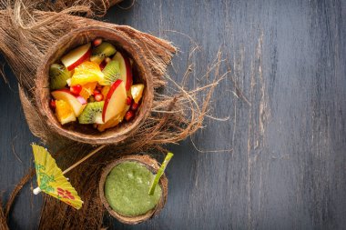 Meyve salatası elma, kivi, portakal ve nar yarım kireç ile taze yeşil smoothies ve Hindistan cevizi ve Hindistan cevizi kabuğu nane. Üstten görünüm. Sağlıklı bir diyet kavramı. Kopya alanı