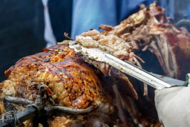 Şef bitmiş kuzu şiş üzerinde parçalara sıcak kömürlerin üzerinde keser. Açık ızgara