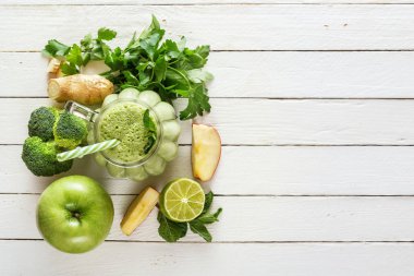 Taze yeşil smoothies maydanoz, zencefilli, elma, limon, salatalık, brokoli ve bir bardak beyaz tahtalar üzerinde çok temiz. Sağlıklı bir diyet kavramı. Kopya alanı