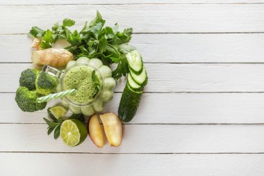 Taze yeşil smoothies maydanoz, zencefilli, elma, limon, salatalık, brokoli ve bir bardak beyaz tahtalar üzerinde çok temiz. Sağlıklı bir diyet kavramı. Kopya alanı