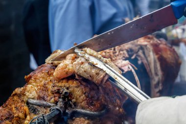 Bir bıçak ve forseps ile el aşçı sıcak kömürlerin üzerinde hazır kuzu şiş üzerinde parçalar halinde kesin. Açık ızgara