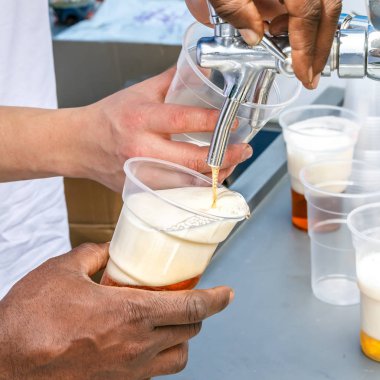 Sokakta ticaret bira. Barmen taze bira gözlük yemyeşil köpük içine yazın