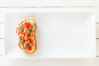 Bruschetta taze domates ve peynirle beyaz tabakta. Üstten görünüm. Kopya alanı