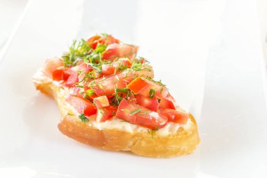 Bruschetta taze domates ve peynirle beyaz tabakta. Yakın çekim
