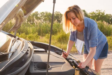 Kız güneşin ışınları bir ülkede yol üzerinde bir araba onarıyor. Portre