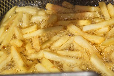 Patates kızartması sıcak yağ özel bir metal ızgara içinde hazırlanır. Yakın çekim. Arka plan resmi