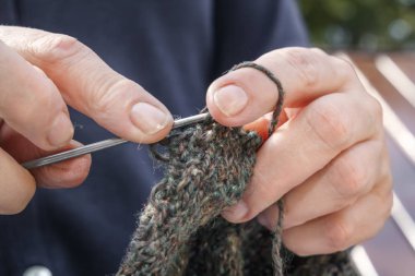 kadın giysi gelen yün örgü iğneleri ile dokuma kumaşlar. Yakın çekim. Kopya alanı.