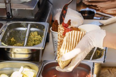 Cook sandviç - dolgu üzerine sos dökülen burrito mutfakta. Sokakta yemek. Fast food