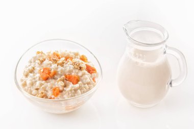 Kabak ve fındık bir cam levha ve bir sürahi beyaz zemin üzerine sütlü yulaf ezmesi. Yakın çekim. Kopya alanı