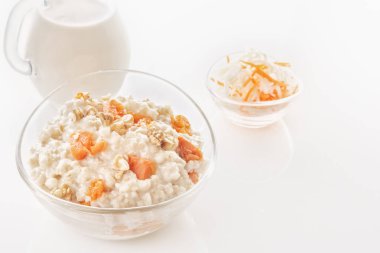 Kabak ve fındık bir cam levha ve bir sürahi beyaz zemin üzerine sütlü yulaf ezmesi. Yakın çekim. Kopya alanı