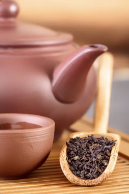 Çay granül bir ahşap tepsi öznitelikleri bir geleneksel çay töreni için arka planı üzerinde özel çay kaşığı yalan içine döktü. Yakın çekim